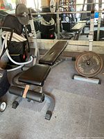 Full view of the weight bench with barbell loaded with weight plates.