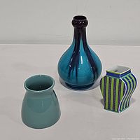 Three blue vases shown from the front: teal fluted, rounded blue with streaks, and small square Rosenthal piece