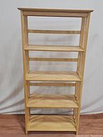 Front view of natural wood 4-shelf folding etagere bookshelf with flat shelves and open sides.