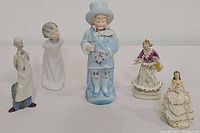 Wide shot of six vintage porcelain figurines showing different characters and styles.
