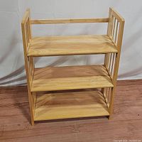Front view showing three spacious shelves and natural wood finish.