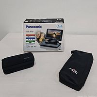 Panasonic DVD player box with storage cases for GoPro and heated gloves on side