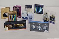 Assortment of Chanukah candles and themed holiday accessories including boxed menorah candles, Star of David candle holders, and dreidel ornaments.