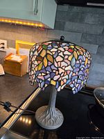 Single assembled lamp with stained glass shade and base on countertop