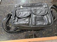 Front view of the black Bentley leather shoulder bag showing multiple front compartments and adjustable strap.