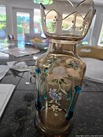 Full view of the vintage glass vase showing enamel floral decoration and blue glass drops, scalloped rim detail.