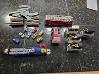 Overview of entire die cast vehicle collection including train, tracks, fire trucks, and small cars seen on countertop