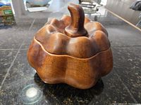 Closed view of the wooden pumpkin lidded box showing carved details and stem handle on top.