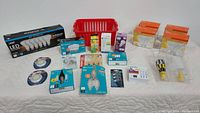 Full assortment including boxed LED bulbs, halogen lamps, loose and specialty bulbs displayed on a white surface with a red basket in background.