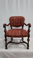 Front view of the Jacobean style arm chair showing detailed upholstery and carved wooden frame.
