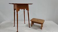 Wood side table and small wood step stool together, showing size comparison and form