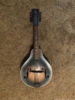Front full view of the 8-string mandolin showing the sunburst finish, f-holes, fretboard, and missing strings.