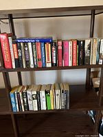 Books arranged on two wooden shelves showing titles including '5000 Jokes for All Occasions,' 'How to Soar With The Eagles,' and others.