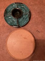 Top view of ceramic serving dish with four detailed sections, placed on round wooden lazy Susan base
