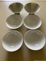 Six plain white round rice bowls with smooth glazed finish shown from above and side angle.