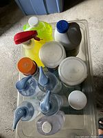 Top view showing multiple bottles of cleaning liquids including bleach and all-purpose cleaner with spray nozzle.