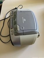 Sony boombox side view showing CD player top, buttons, and power cord.