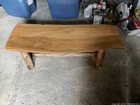 Angled top view of teak bench showing natural wood finish and missing end piece.