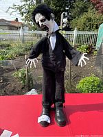 Front view of the zombie Halloween animatronic figure standing upright outdoors, showing its costume and facial details.