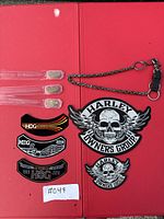 All items photographed together showing patches and pins, with a chain accessory