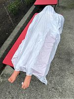 Top view photo showing the animatronic covered by a white sheet with realistic feet sticking out