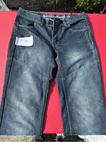 Front view of dark denim motorcycle pants with faded areas and reinforced seams.