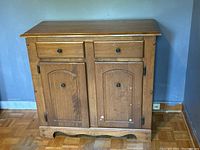 Front angle view of maple wood server cabinet showing drawer and door details