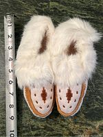 Top view showing white fur trim and brown beadwork on the top of the moccasins.