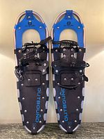 Pair of Outbound snowshoes showing front and top view with straps and metal frame intact