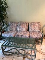 Full view of rattan couch with patterned cushions and rattan coffee table beneath it