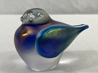 Side view of iridescent wing and frosted body of crystal bird figurine.
