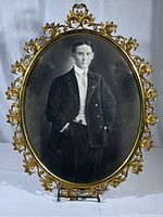 Full view of the large oval metal Art Nouveau style frame with the Victorian gentleman's portrait inside.