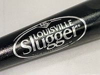 Close-up of the black Louisville Slugger logo on the bat.