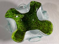 Top angle view showing the green interior with gold speckles and undulating rim of the hand-blown glass dish.