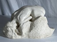 Side view of white ceramic sculpture of reclining female figure draped over a textured base, showing Rodin and ALVA signature.