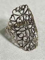 Front view of a sterling silver ring with flower and heart filigree design, showing intricate openwork and details.