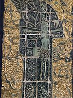 Close-up of the gold and green cast tiles showing the relief sculpture of Christ on the cross with detailed texture and segmented tiles.