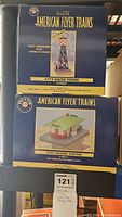 Both original boxes of American Flyer Trains accessories, #772 Water Tower and #755 Talking Station, stacked one on top of the other.