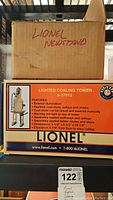 Two cardboard boxes stacked, one labeled 'Lionel Newsstand' and one printed Lionel Lighted Coaling Tower box labeled 6-37912.