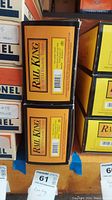 Side view of Rail King branded boxes stacked on shelf with lot tags