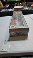 Boxed Lionel train set with model diesel engine and caboose visible through clear display window.