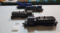 Four Lionel model train locomotives shown on a table including Erie 610, Reading 100, Chesapeake & Ohio 624, and Jersey Central 621.