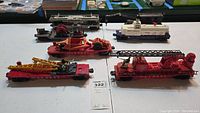 Wide shot of six red metal flatcars with various attachments