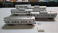 Five silver Lionel Lines Summit and Clifton Dome model train passenger cars on a surface.
