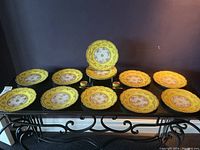 Twelve plates arranged on a table with one plate displayed upright in center