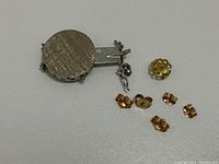 Slide clasp and six earring backs arranged on white background