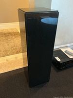 Full front view of polished black granite pedestal standing upright