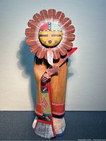 Front view of the carved Hopi Kachina figure showing the full body, robe details, and feather headdress.