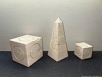 Full view of all three sculptures on dark surface, showing relative sizes
