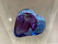 Front view of Kosta Boda heart-shaped art glass paperweight displaying blue and purple internal colors.